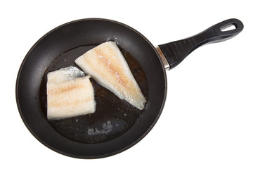 Hake fillets in the pan. Isolated on white background
