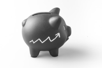 Black piggy bank with chalk graph sketch.