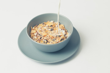 Muesli bowl with milk stream. Vintage style.