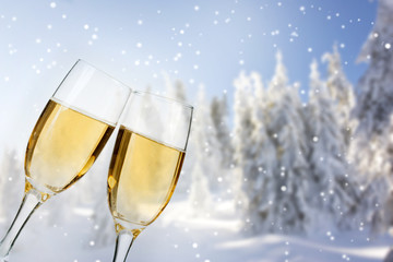 Glasses with champagne on winter background