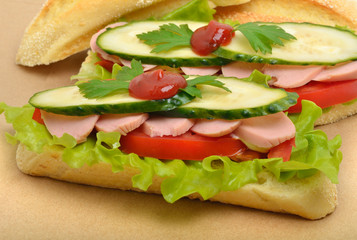 Big appetizing fast food baguette sandwich with lettuce, tomato