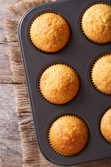 Golden delicious muffins in baking dish vertical top view