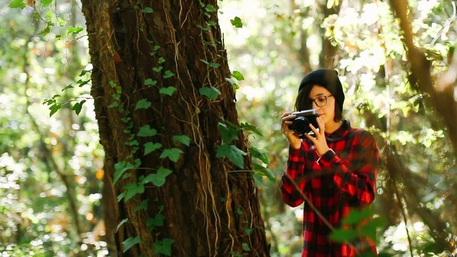 Hipster girl taking photo in the forest