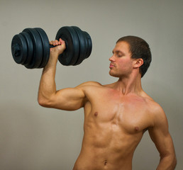 Fototapeta na wymiar Handsome muscular male model with dumbbell.