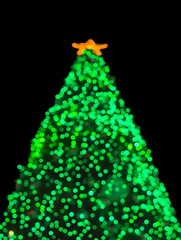 Christmas tree as green circle bokeh on black background
