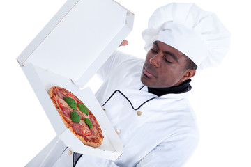 Afroamerikanischer Koch riecht an Pizza im Karton Porträt