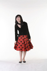 빨간 스커트를 입고 있고 제스처를 취하는 아시안 여성 