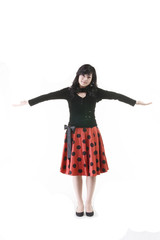 빨간 스커트를 입고 있고 제스처를 취하는 아시안 여성 