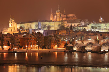 Night colorful snowy Prague gothic Castle with Charles Bridge