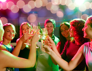 smiling friends with wine glasses and beer in club