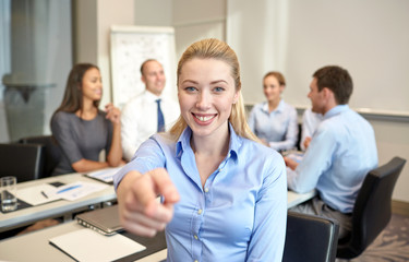 group of smiling businesspeople meeting in office