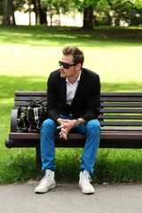 Obraz premium Man sitting down on a bench