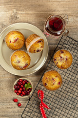 Muffins with cranberry on cooling rack on wooden background.