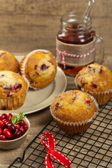 Muffins with cranberry on cooling rack on wooden background.