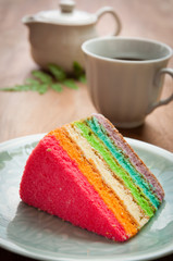 Delicious rainbow cake on plate on table