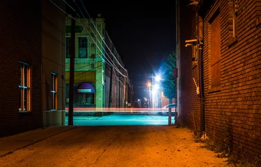 Fotobehang Dark alley and light trails in Hanover, Pennsylvania at night. © jonbilous