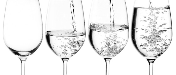 pouring water on a glass on white background