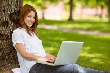 Pretty redhead sitting with her laptop