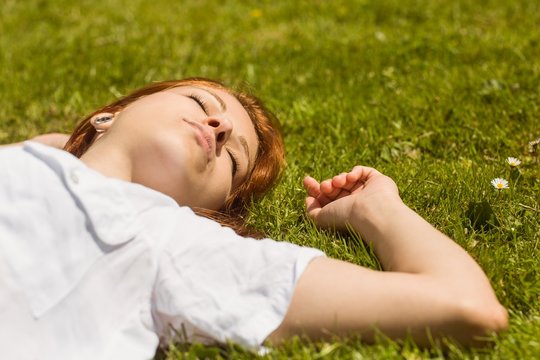 Pretty redhead napping on grass