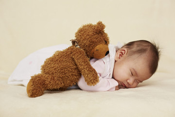 Baby und Teddybär schlafen