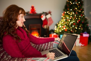 Content redhead using laptop at christmas