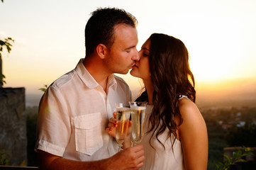 Obraz premium Toast young couple kissing at sunset