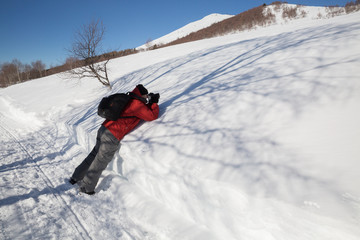 Nature photographer taking photos in the snowy mountain