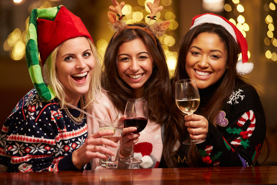 Group Of Female Friends Enjoying Christmas Drinks In Bar