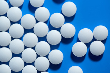 pills. White medical pills on blue background