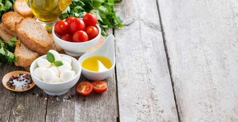 mozzarella and ingredients for the salad on a wooden background