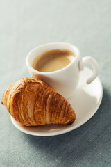 Breakfast concept: cup of coffee and croissant