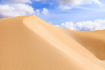 Fototapeta na wymiar Sand dunes in Boavista desert with blue sky and clouds, Cape Ver