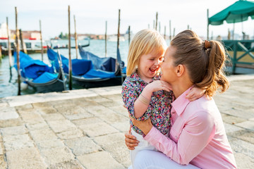 Portrait of happy mother and baby on grand canal embankment 