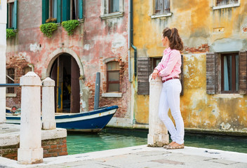 Fototapeta na wymiar Young woman standing on street in venice, italy 