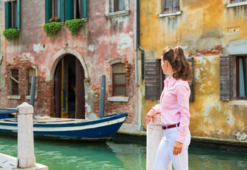 Fototapeta na wymiar Young woman looking on canal in venice, italy. rear view