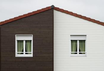 Giebel mit Fassadenplatten und zwei Fenstern mit Rollläden