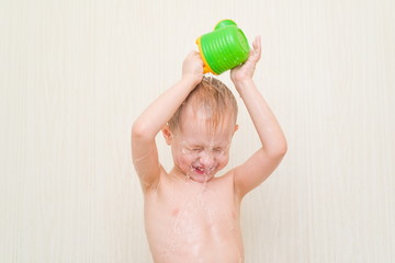 little boy in the bathroom on a white background pour it on his