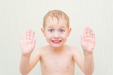 Surprised boy showing his hands in the bathroom