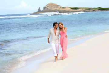 Fototapeta na wymiar Romantic couple walking on a sandy beach
