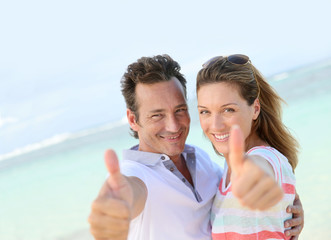 Happy couple showing thumbs up to camera