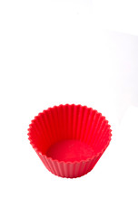 Red silicone cupcake baking cups over white background 