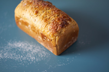 A loaf of fresh bread lying on colored surface