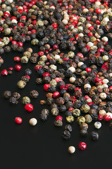 Red, black, green and white peppercorns
