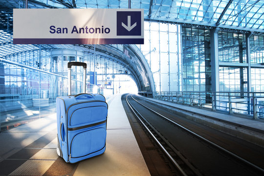 Departure For San Antonio. Blue Suitcase At The Railway Station