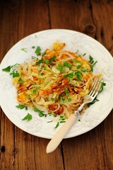 Fried potatoes on white plate with fork