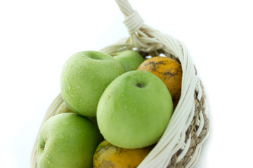 basket of green apples on white background