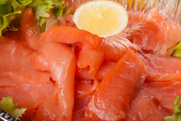 sliced salmon laid in a bowl with lemon. tinted
