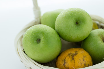 basket of green apples on white background