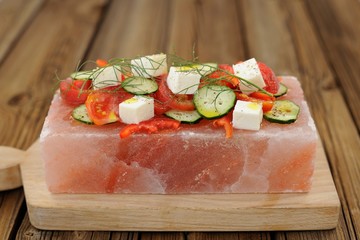 Vegetable and cheese salad served on a block on himalayan pink s