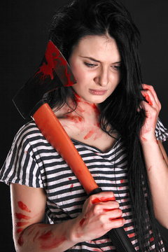 Young woman with a big bloody axe